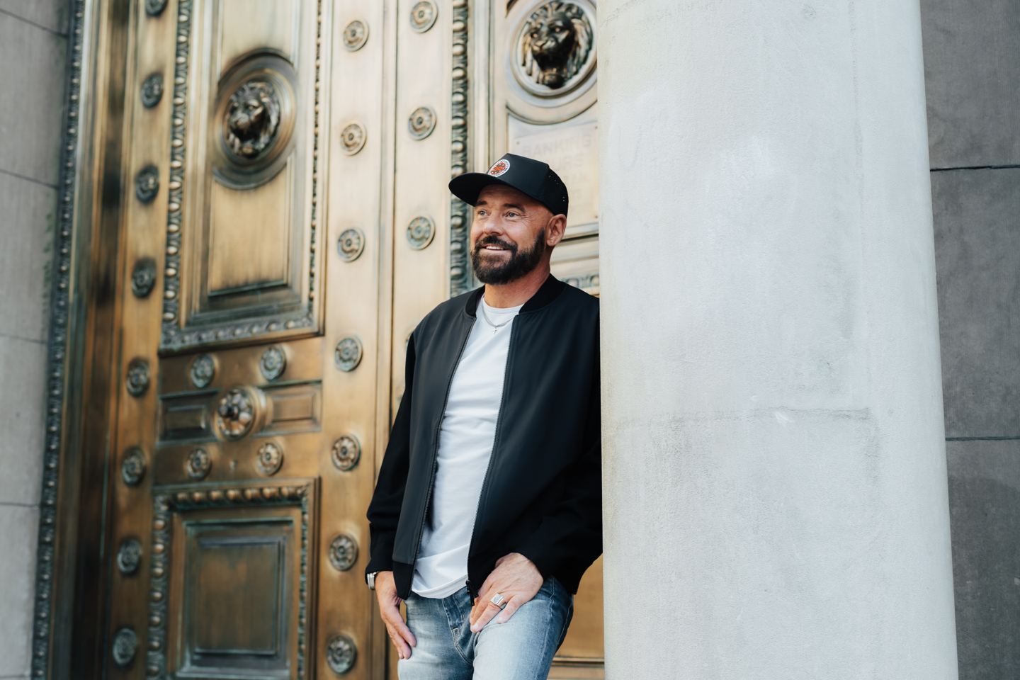 Shawn Feurer smiling in front of a bronze door