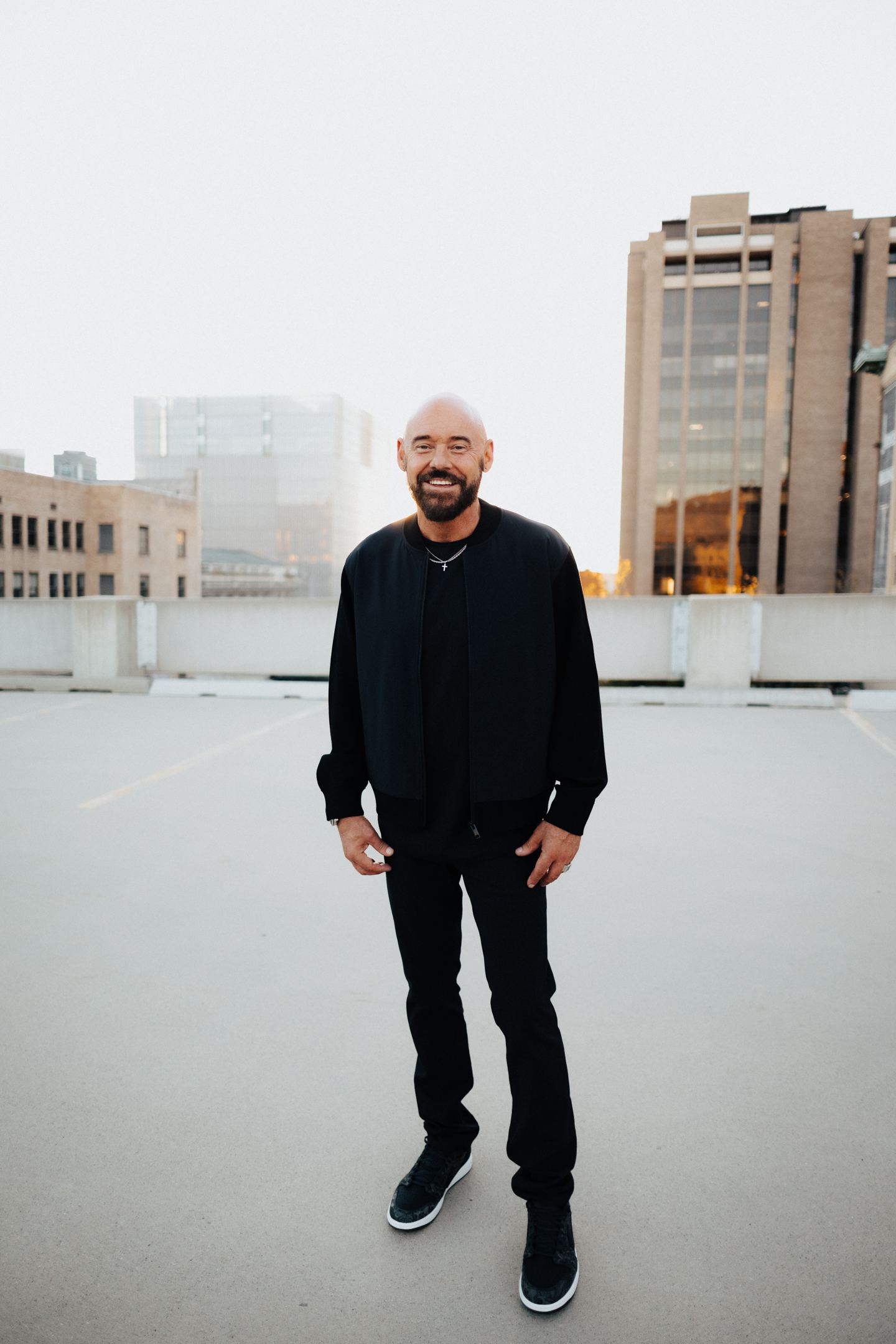 Shawn Feurer, entrepreneur and mindset mentor, smiling on a city rooftop